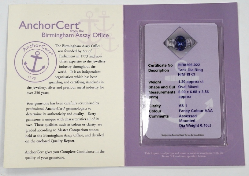 A modern 18ct gold and single stone oval cut tanzanite set ring, with baguette cut diamond cluster set shoulders, with accompanying AnchorCert report, stating the stone to weigh 1.20ct, size L, gross weight 4.1 grams. Co